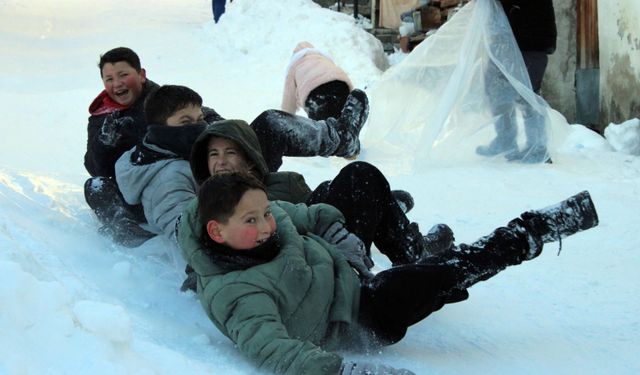 Mahalle yolunu kızak pistine çeviren çocuklar karın tadını çıkardı